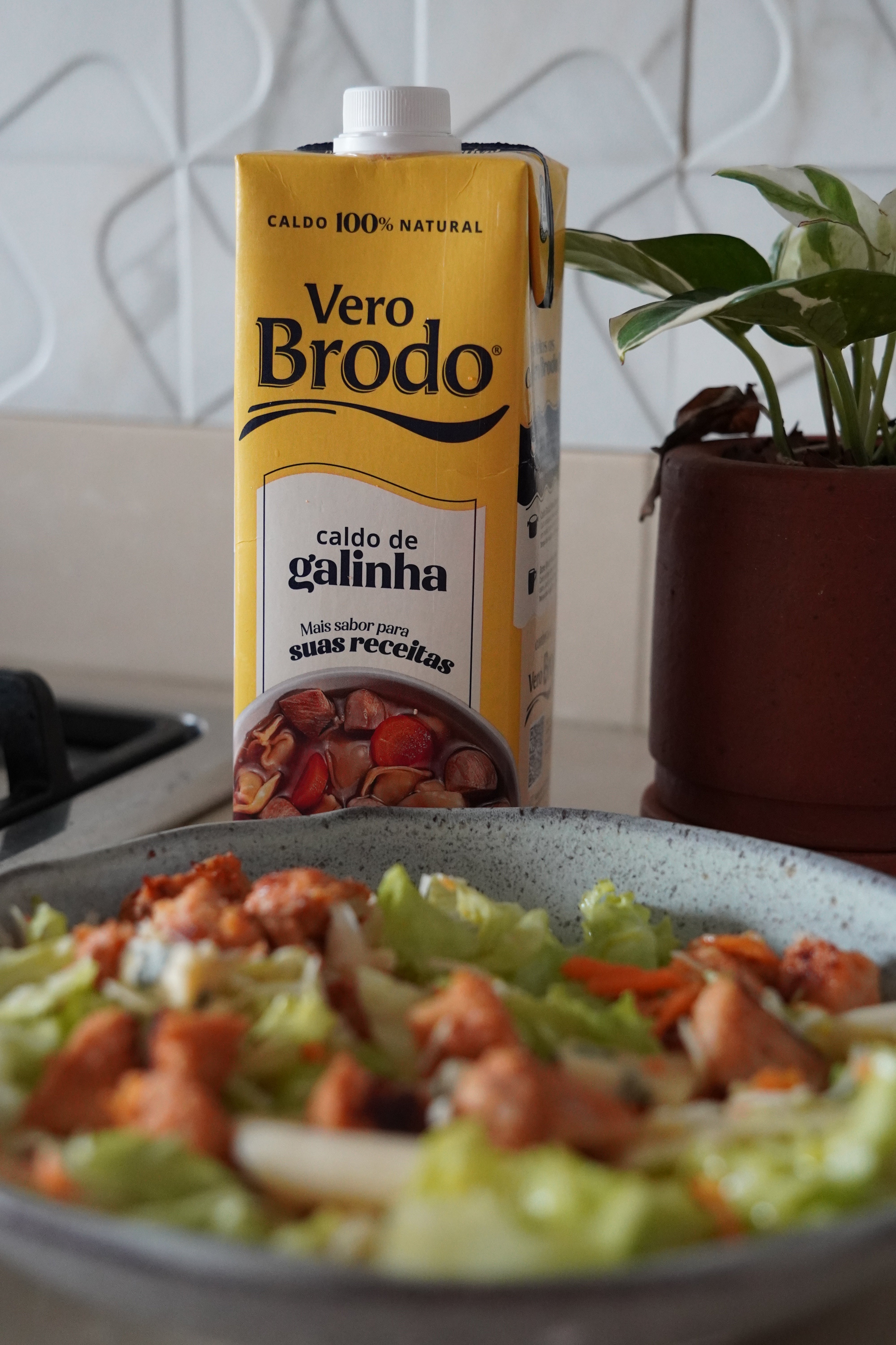 imagem do caldo de ossos de galinha da vero brodo com um prato de salada verde refrescante com frango