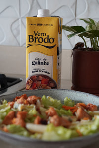 imagem do caldo de ossos de galinha da vero brodo com um prato de salada verde refrescante com frango